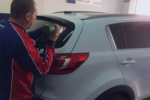 Técnico de Glass DV Getafe trabajando en la luna trasera de un coche en el taller de Getafe